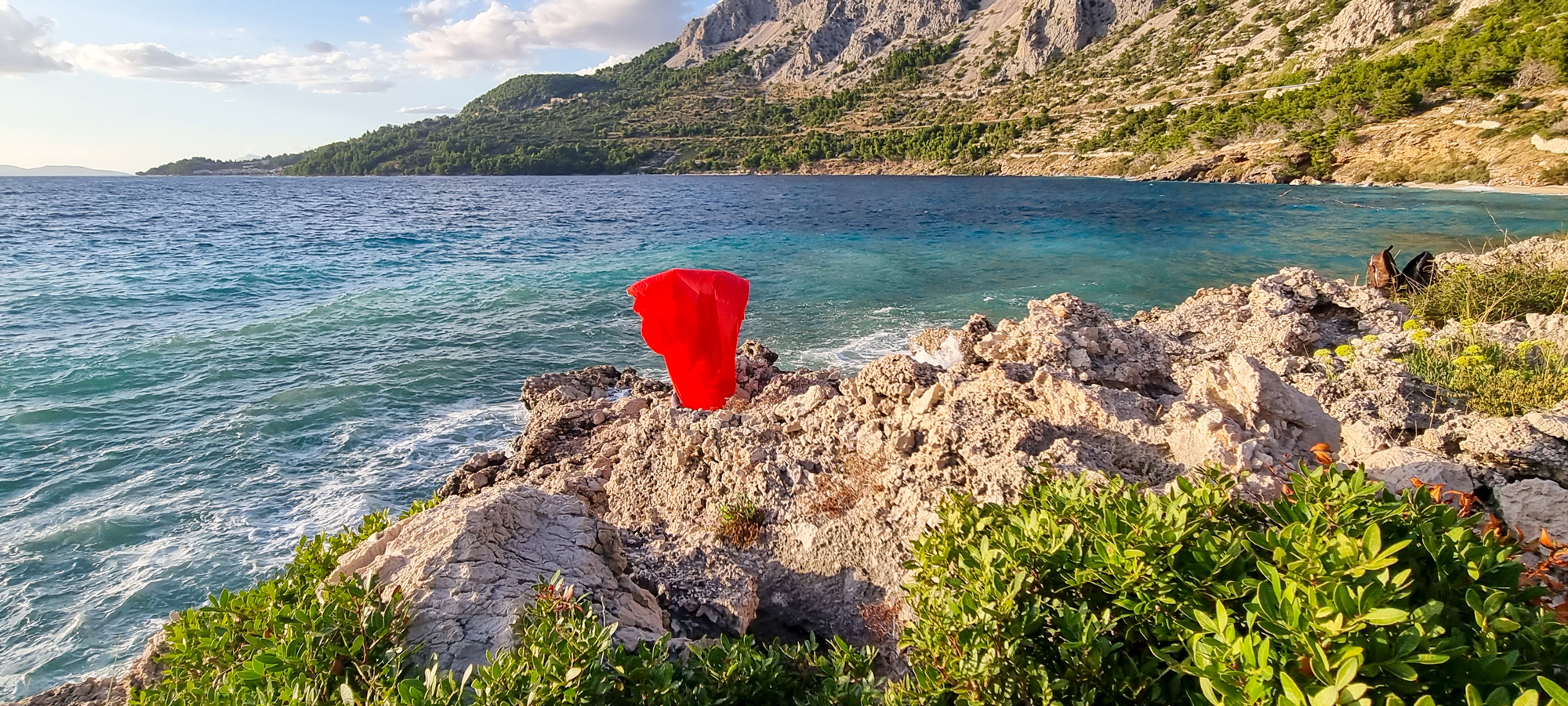 Croatia landscape, artist wrapped in vivid red cloth